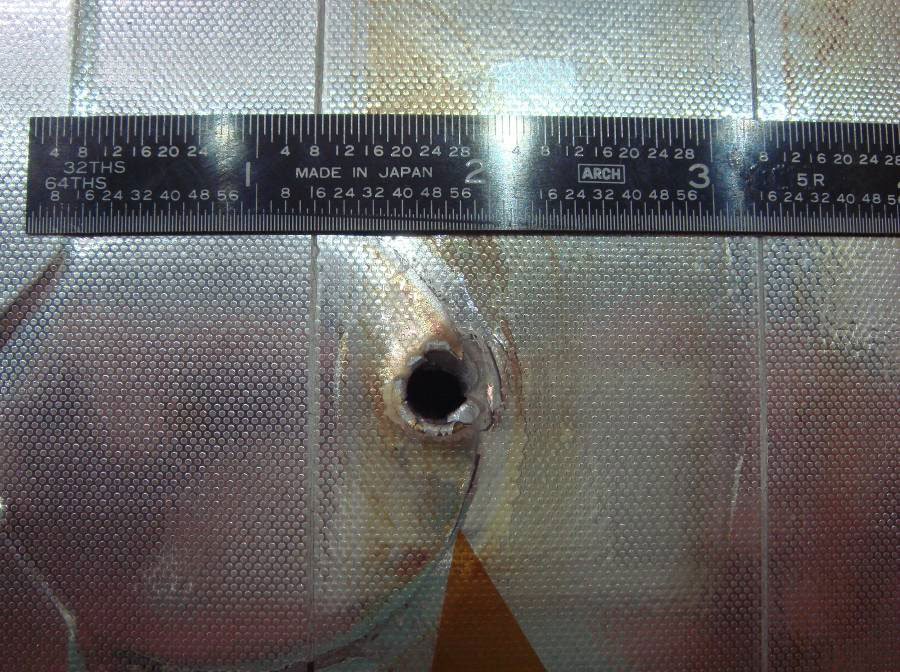 Časť z vesmírneho odpadu vyrazila tento otvor v chladiči raketoplánu Endeavour. Zdroj: NASA