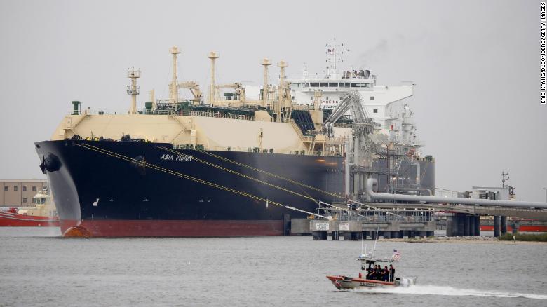 Loď americkej pobrežnej stráže prechádza popri prepravnej lodi Asia Vision pre skvapalnený zemný plyn (LNG) kotviacej v texaskom termináli Sabine Pass.